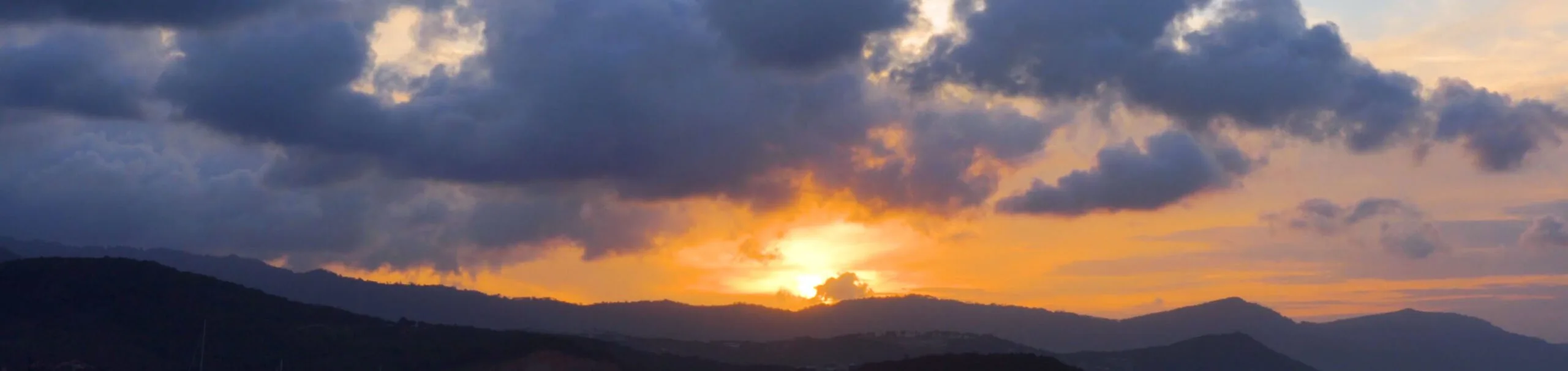 Atardecer con nubes doradas y montañas en silueta